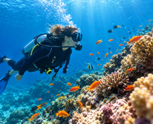 Plongeuse sous-marine explorant un récif corallien avec des poissons tropicaux